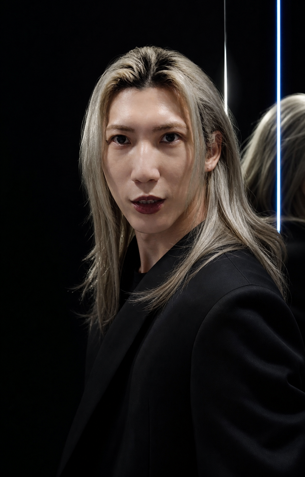 黒いスタジオでカメラを見る男性モデルROMANÉEの宣材ポートレート